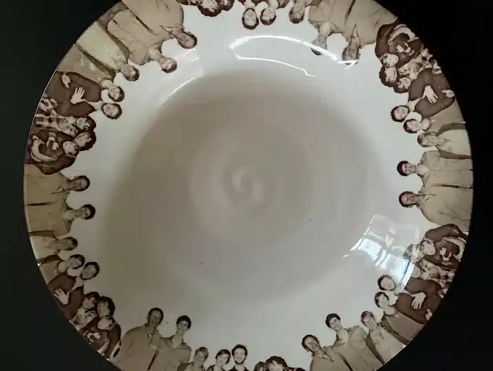 Een schaal van keramiek met daarop een decoratie van fired-on images