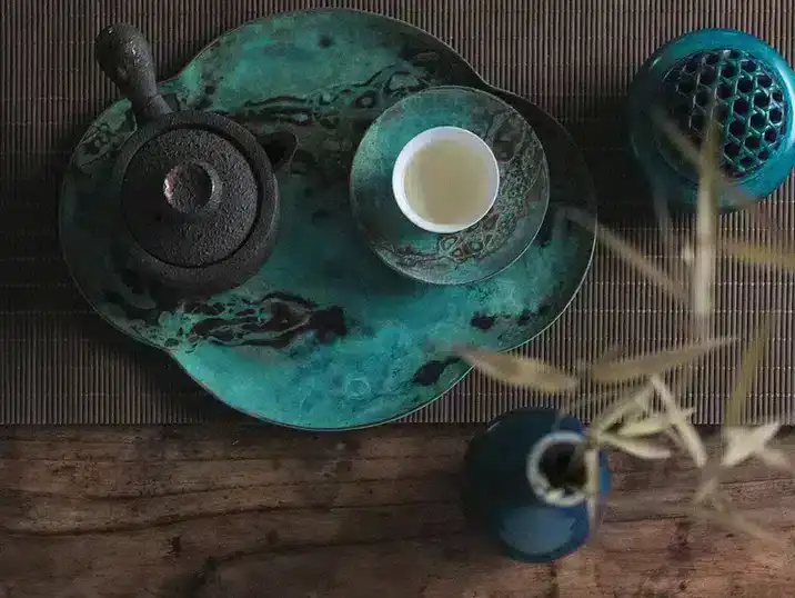 A green tea set with a ceramic tray and tea cup