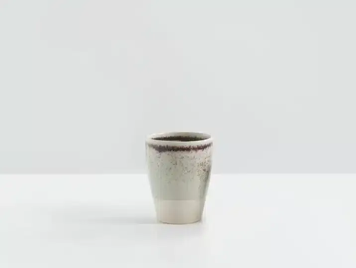 Een beker van keramiek met lusters geglazuurd