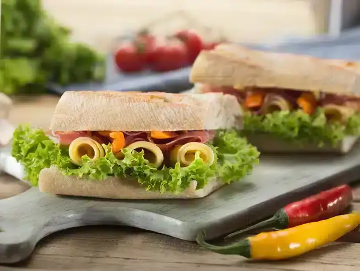 Een broodplank van keramiek met daarop belegde broodjes