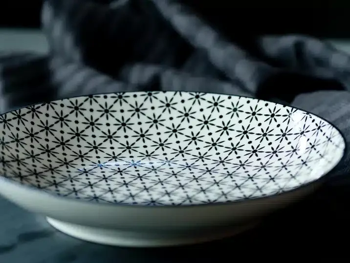 Een schaal van keramiek gedecoreerd met een zwart motief aangebracht met een decal