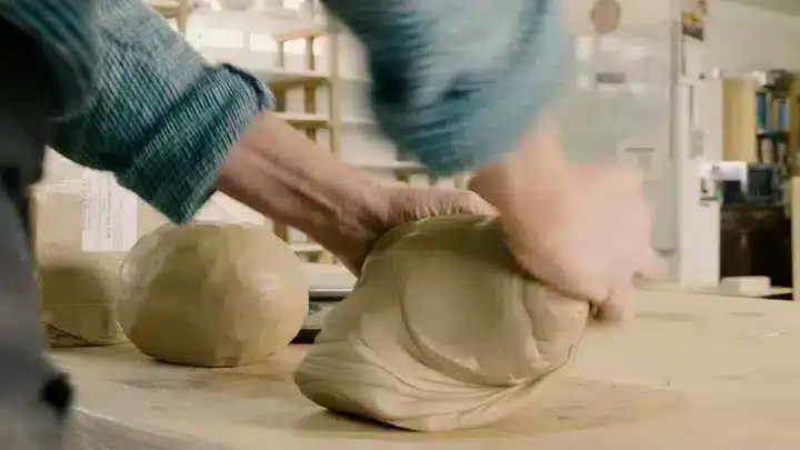 Cursist docente Françoise Busin die een bol klei kneedt volgens de ossenkopmethode