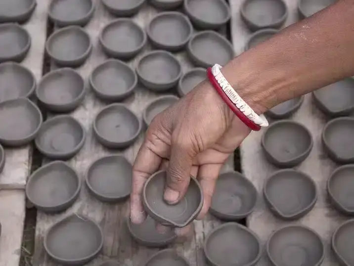 Wanneer klei droog: een hand en veel kommetjes van klei die lederhard is