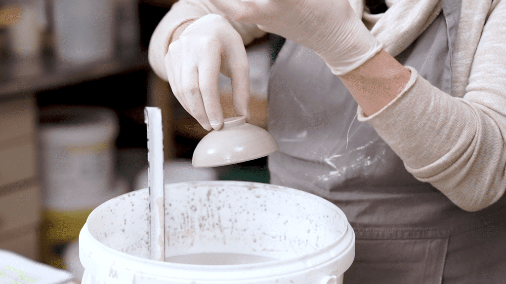 Glazuren voor beginners: Aster Caemaert tijdens het glazuren van een kommetje volgens de domspelmethode