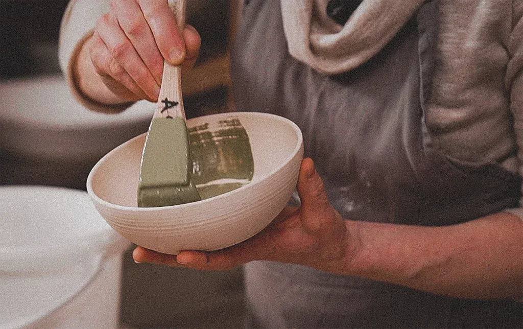 Een kom glazuren met de kwast