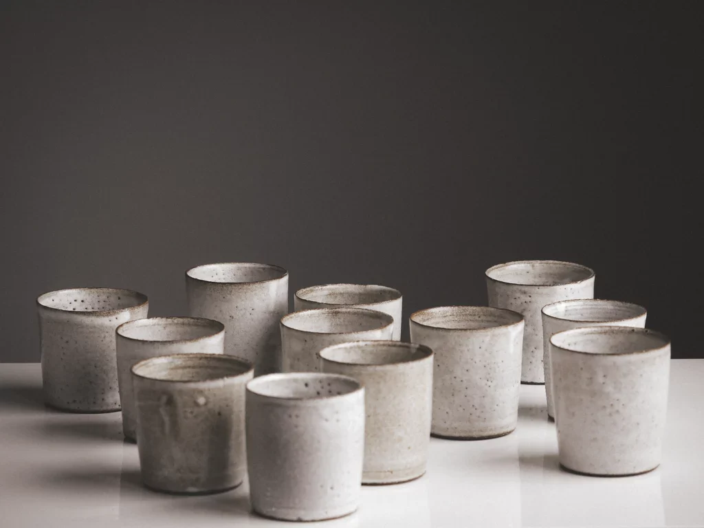 Verschillende witte gespikkelde bekers van keramiek