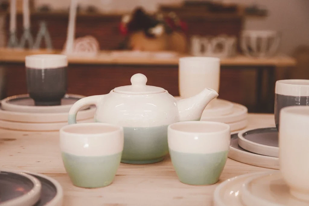 Verschillende kommetjes, borden en een theepot van keramiek, halfgeglazuurd in groen en grijs