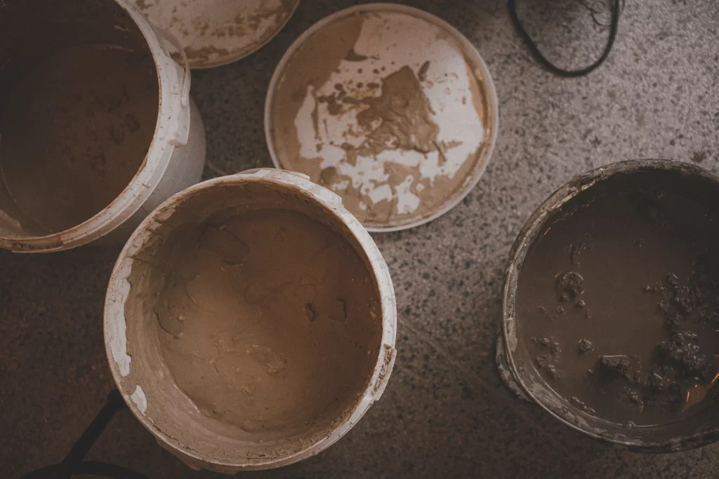 Witte emmers met kleislib in een keramiekatelier
