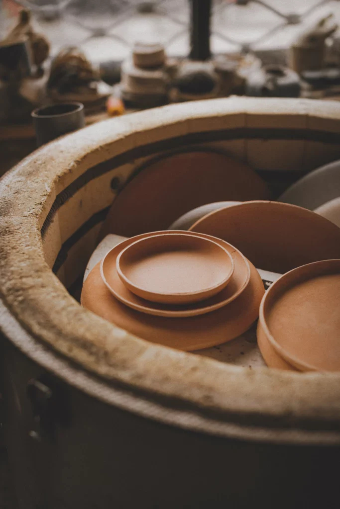 een openstaande keramiekoven met daarin borden en kommen