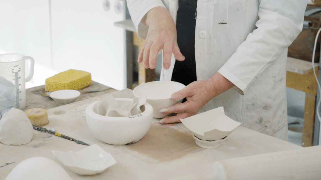 Hoe maak je papierklei: Anima Roos staat voor een tafel met papier in mallen