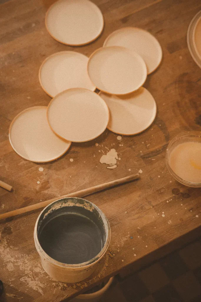 Keramiek glazuren op tafel met borden van keramiek en glazuuremmer
