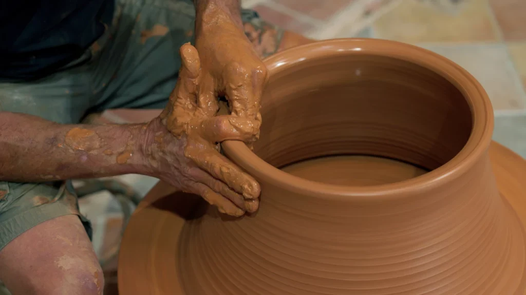 Online keramiek leren: Rudie draait en centreert het tweede deel van de pot omgekeerd