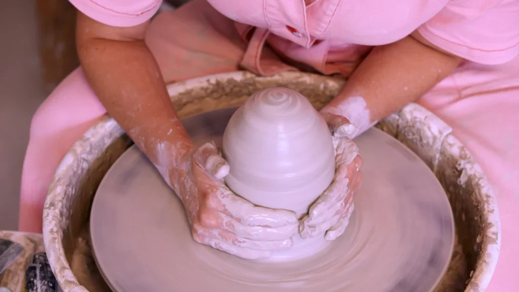 Draaiplateau keramiek: Sofie De Cleene centreert bol klei met haar handen op de draaischijf