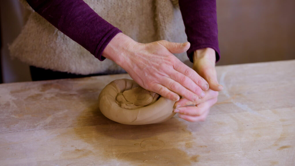 Aster Caemaert demonstreert spiraalkneden in een pottenbakken cursus