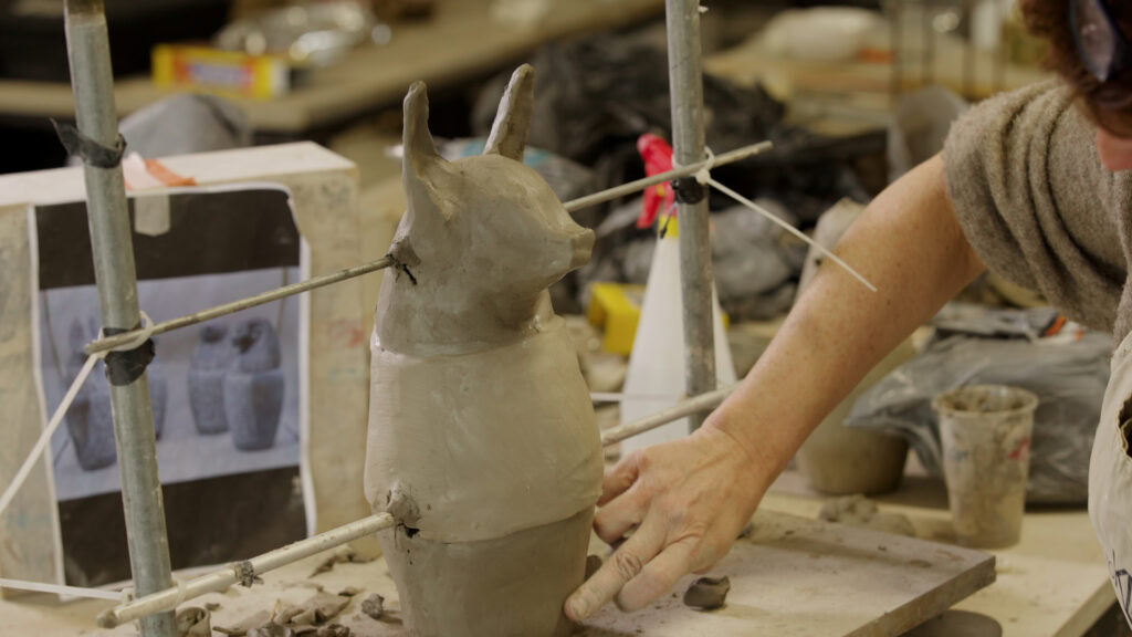Beelden boetseren: aanduiden met vinger op hondje uit klei
