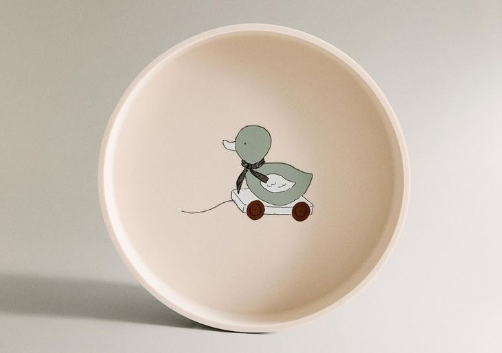 Het kinderbord in keramiek beige met groen eendje op wieletjes op